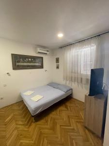 a bedroom with a bed and a television in it at Apartments Adriatic Nest in Omiš