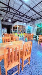 a large wooden table and chairs in a restaurant at I Hug Homestay ไอฮัก ที่พักเชียงใหม่ in Ban Thap Dua