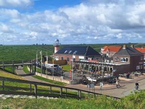 a lighthouse in the middle of a town with a building at Vakantiewoning Koestraat 48A met strandcabine in Westkapelle