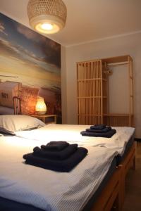a bedroom with a bed with black towels on it at FeWo Adele ruhige Auszeit am Dümmersee in Hüde