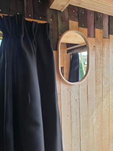 a black dress and a mirror on a wall at Ardennen Kotje in Durbuy +2 photos