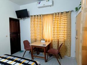 a room with a table and chairs and a window at Cloud9 Lomé in Lomé