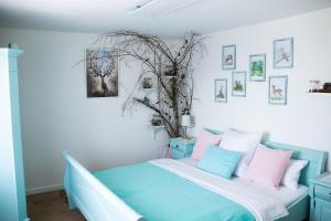 a bedroom with a blue bed with pink and blue pillows at Buntes Bergglück 1923 in Ober-Gossen