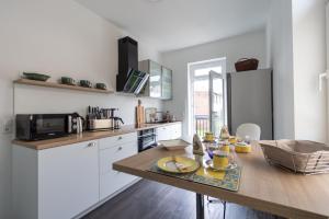 a kitchen with a wooden table and a counter top at Exklusives Appartement mit Flair in Oelsnitz