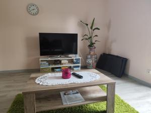 a living room with a tv and a coffee table at Gästehaus Ruhepol in Bissendorf