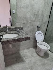 a bathroom with a toilet and a sink and a mirror at Henri Karam in Brumadinho +5 photos
