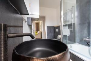 a bathroom with a black sink and a tub at Exklusives Appartement mit Flair in Oelsnitz +20 photos