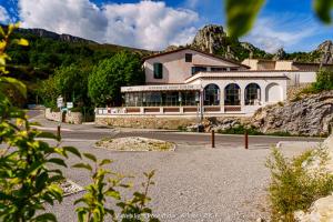 a building on a mountain with a road in front of it at Auberge du Point Sublime in Rougon