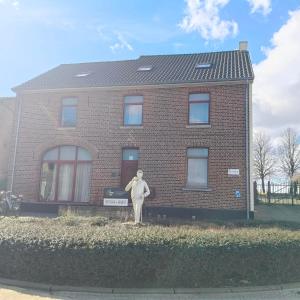 a statue of a person standing in front of a building at De Smokkelhoeve in Riemst