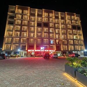 a large building is lit up at night at Motus Mountain view Hotels in Jambhulpāda