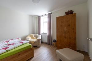 a bedroom with a bed and a chair and a window at Exklusives Appartement mit Flair in Oelsnitz
