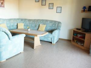a living room with a blue couch and a coffee table at Ferienwohnung Arber in Dösingerried