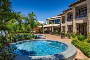 a swimming pool in front of a house at Quinta do Sol Praia Hotel in Porto Seguro +46 photos