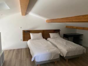 two beds in a room with white sheets and pillows at Alata Appartement T3 in Alata