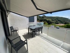 a patio with a table and chairs on a balcony at Alata Appartement T3 in Alata