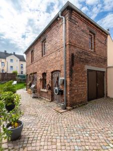 an old brick building with a brick driveway at Exklusives Appartement mit Flair in Oelsnitz