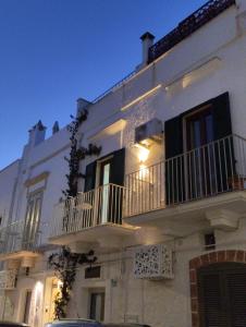 a white building with two balconies on the side of it at Dimora Dioniso in Polignano a Mare