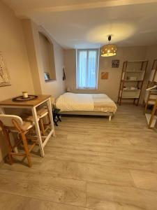 a bedroom with a bed and a desk and a table at Studio Cosy avec Cour Privée in Fleury