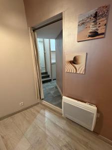 a hallway with a mirror and a heater in a room at Studio Cosy avec Cour Privée in Fleury