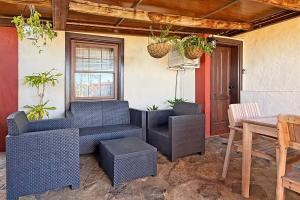 a patio with blue wicker chairs and a table at Casa El Colmenero in Garafía