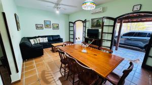 a living room with a wooden table and a couch at Casa Lar Doce Mar Juquehy in São Sebastião