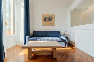 a blue couch in a living room with a table at Promenade Maison de Charme in Sanremo