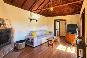a living room with a couch and a television at Casa El Colmenero in Garafía