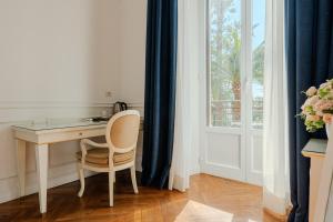 a desk with a chair in a room with a window at Promenade Maison de Charme in Sanremo