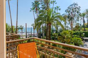 a balcony with palm trees and a view of the ocean at Promenade Maison de Charme in Sanremo