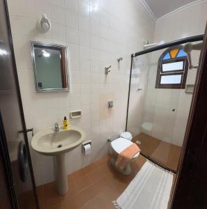 a bathroom with a shower and a sink and a toilet at Casa Lar Doce Mar Juquehy in São Sebastião