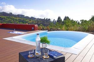 a swimming pool with a table and a bottle of water at Casa El Colmenero in Garafía