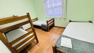 a room with two bunk beds and a window at Casa Lar Doce Mar Juquehy in São Sebastião