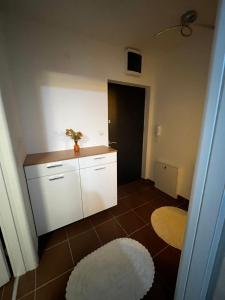 a kitchen with white cabinets and a white rug at Bingo CC Tuzla in Železnička Stanica Tuzla