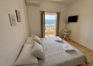 a bedroom with a bed and a view of the ocean at Apartments Ela in Neum