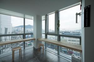 a room with a table and two chairs and windows at K-Guesthouse Premium Nampo 1 in Busan