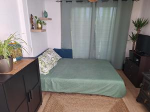 a bedroom with a green bed in a room at A l'Est d'Eden in Hastière-Lavaux