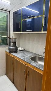 a kitchen counter with a sink and a mirror at Rsheen Inn in Peshawar