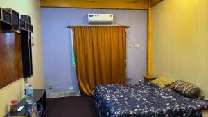 a hotel room with a bed and a heater on the wall at Rsheen Inn in Peshawar