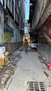 a person walking down a street in an alley at Rsheen Inn in Peshawar