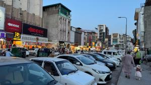 a busy city street with cars parked on the street at Rsheen Inn in Peshawar +16 photos
