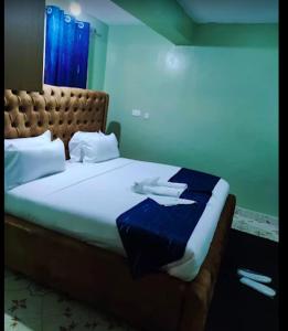 a bedroom with a large bed with a blue at Maya Holiday Point in Ogembo