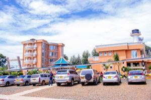 a parking lot with cars parked in front of a building at Maya Holiday Point in Ogembo