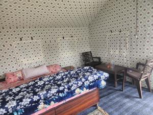a bedroom with a bed and a table with a chair at New Kufari Apple Valley camping in Shimla +5 photos