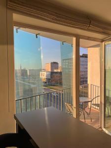 a balcony with a table and a view of a city at Spacious Apartment with 2 Balconies in Klaipėda
