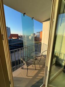 a balcony with a table and a chair on it at Spacious Apartment with 2 Balconies in Klaipėda