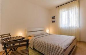 a bedroom with a bed and a table and a window at Gorgeous Apartment Garma in Kavran