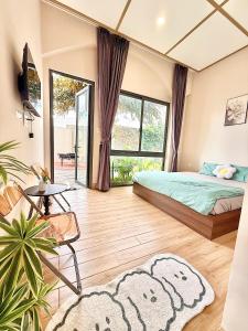 a bedroom with a bed and a large window at K'TY Homestay Phan Thiết in Ấp Bình Hưng