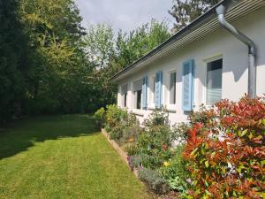 a house with blue shutters and a yard at Gartenchalet Rotkehlchen in Bad Homburg vor der Höhe