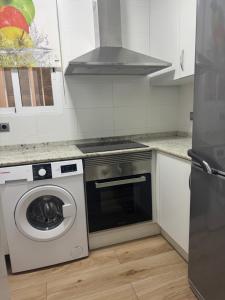 a kitchen with a stove and a washing machine at Dalia Somhome in Peniscola