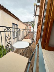 a balcony with a table and chairs on a building at HYDRA Central House in Hydra